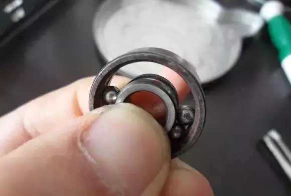 用手將軸承拿起，需要注意要向有滾珠的方向頂住